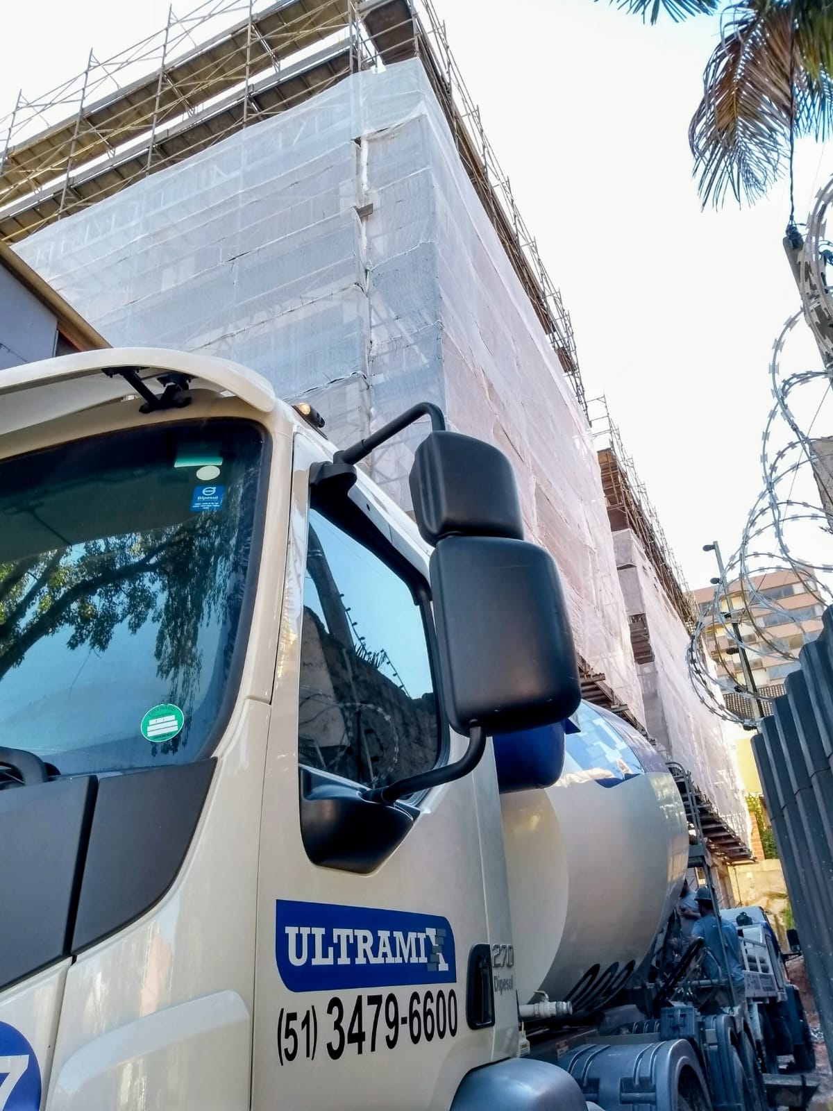 Detalhe de caminhão Ultramix ao lado de uma obra em execução.